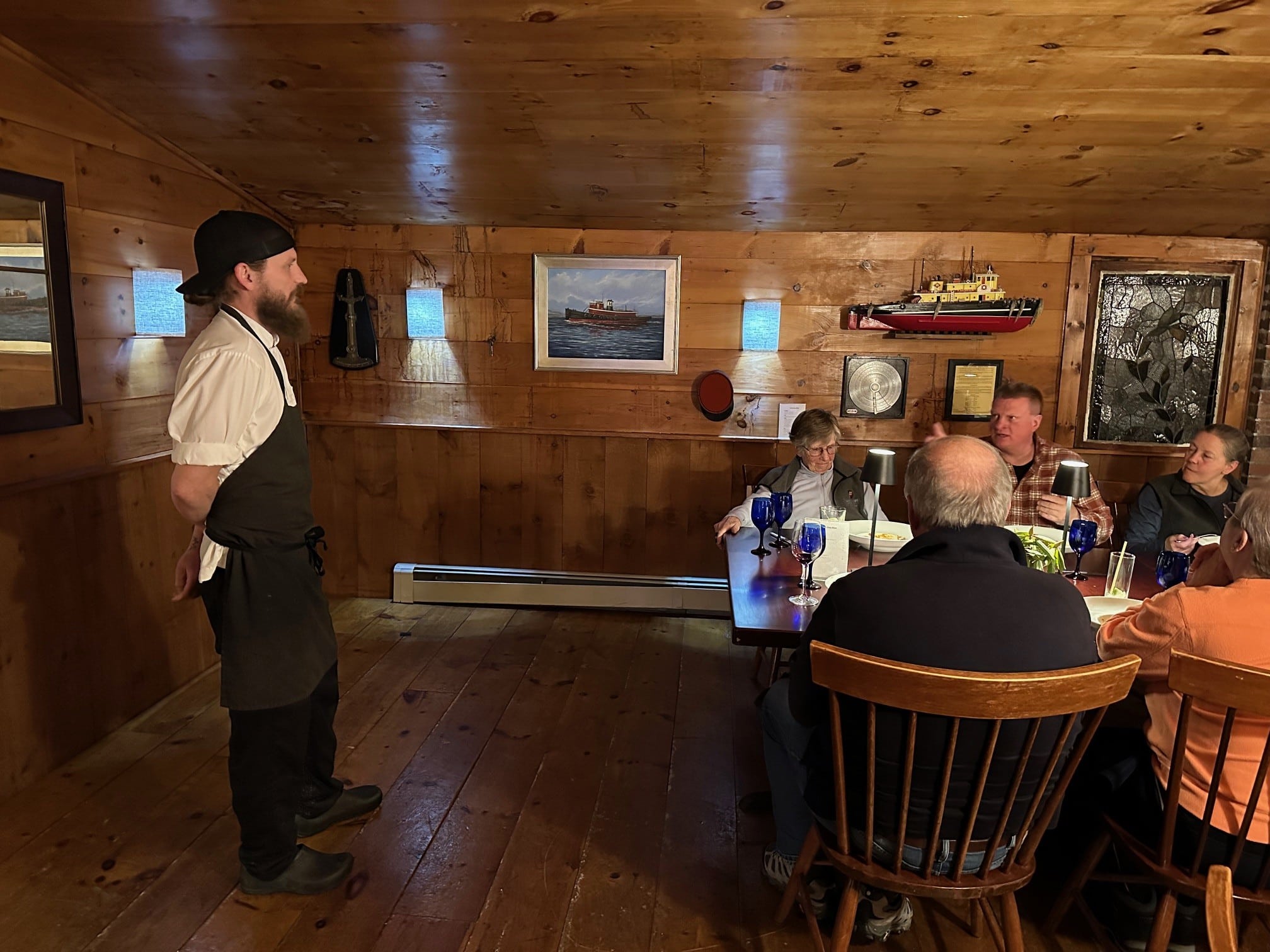 Chef Ross Moskwa speaking to a group of people in the tavern after dinner