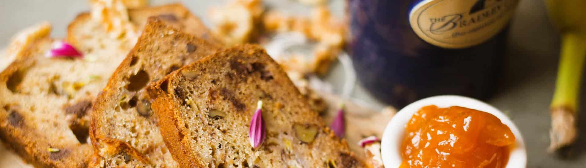 Close up view of banana bread, apricot jam, and stonewear mug