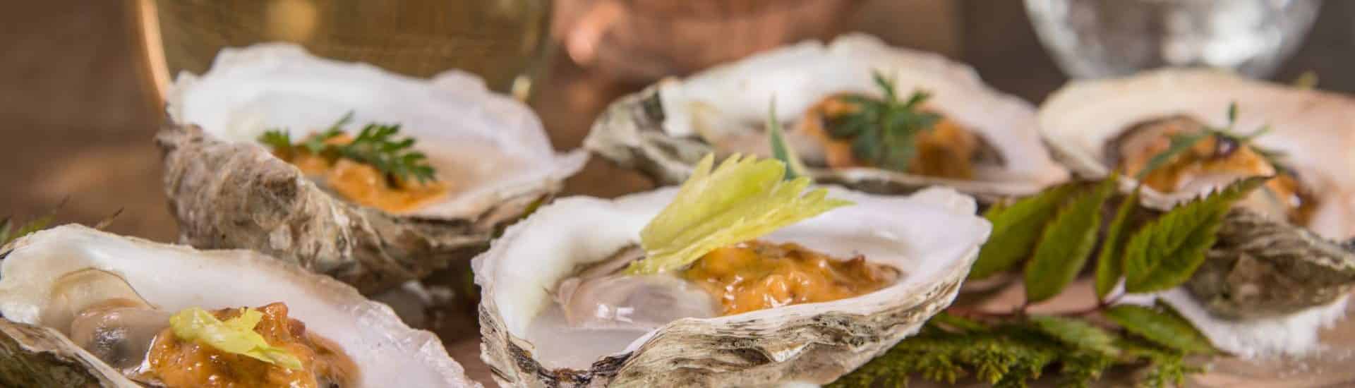 Close up view of oysters on wooden slab